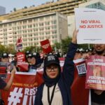 Kumpulan massa aksi #RevisiUUITE membawa spanduk hingga poster-poster aksi. Salah satunya bertuliskan "No viral no justice"